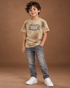 Beige Kids’ Flindall’s Star Graphic T-Shirt, child model front three-quarter view. T-shirt only.