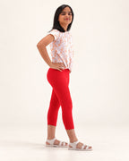 Three-quarter view of girls’ red capri leggings, showing the fit and capri-length hems.