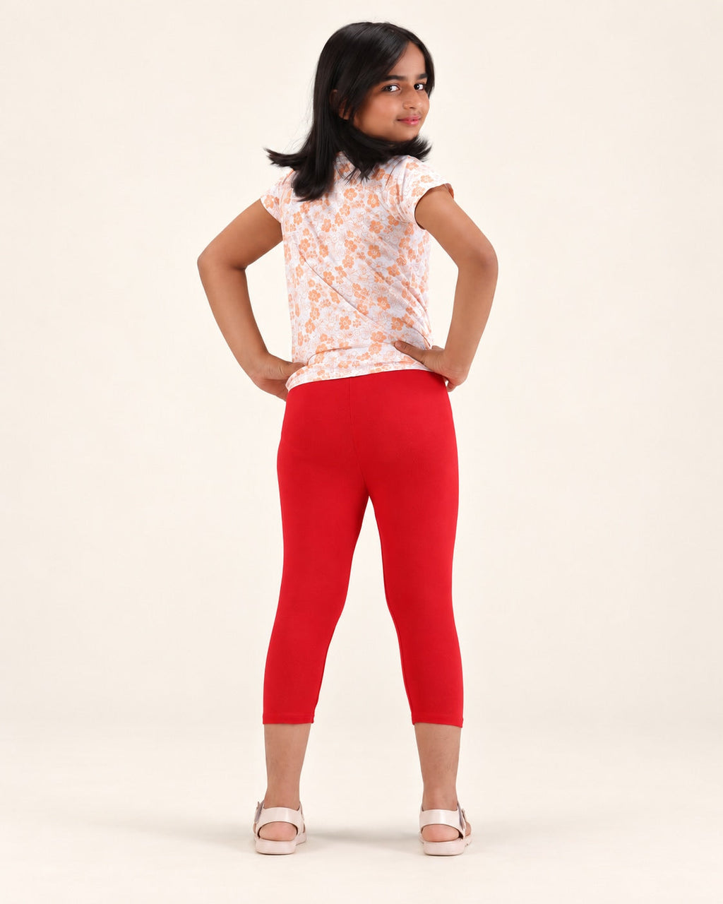 Rear view of girls’ red capri leggings.