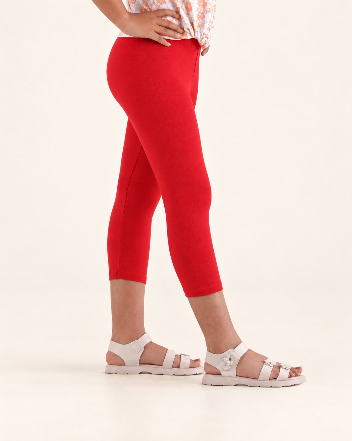 Side detail of the red capri leggings, showing the waist, leg shape and hem.